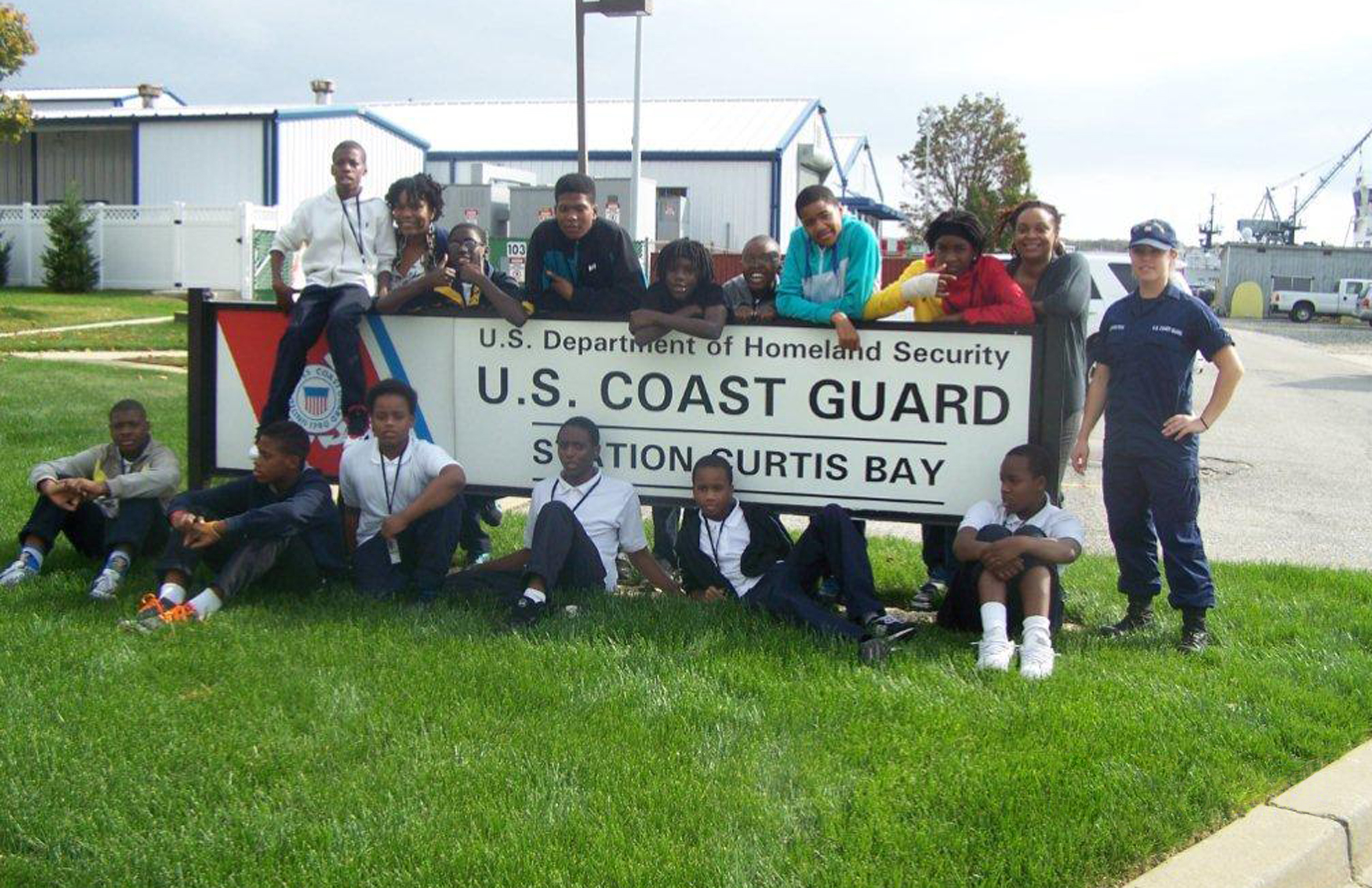 Coast Guard personnel, students, and educators posing at various Partnership In Education locations
